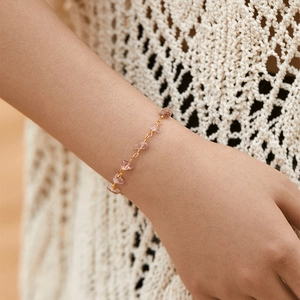 Handmade 18K gold beaded bracelet with irregular pink natural stones on woman's wrist