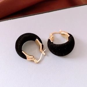 Gros plan détaillé des boucles d'oreilles rétro noires avec pendentifs dorés en U