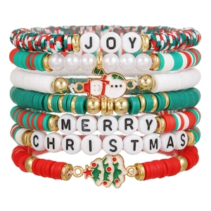 Close-up of Christmas stack bracelets with red green clay beads and festive charms
