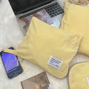 Macro view of bright yellow waterproof travel storage bags on a plush white carpet