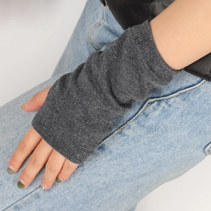 Close-up of dark grey knitted fingerless arm warmers with a flexible ribbed texture