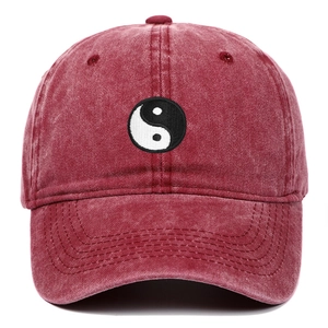 Detail of burgundy washed cotton baseball cap with embroidered Yin Yang Tai Chi symbol