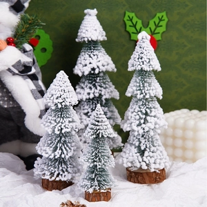 Set of four mini flocked Christmas trees with snowy needles and natural wood bases