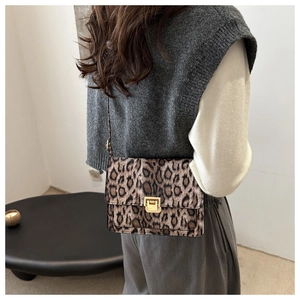 Détail d'un sac à main tendance léopard avec boucle dorée carrée sur le rabat texturé