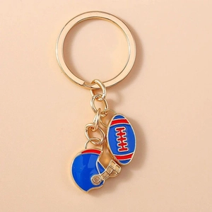 Detail of golden keychain with red-blue rugby ball and American football helmet charms