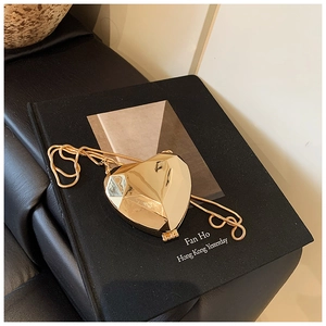 Detail shot of a golden heart-shaped faceted pendant on a matching snake chain