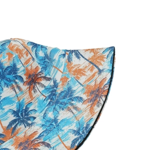 Detailed close-up of tropical palm tree print and twill fabric texture on sun hat
