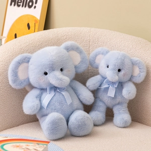 Cute light blue plush elephant dolls with checkered bows on a cozy armchair