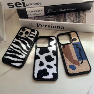 Detailed plush iPhone case collection with zebra, cow patterns and abstract face embroidery