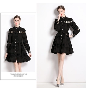 Detail of black lace patchwork on a high neck long sleeve dress with ruffled hem