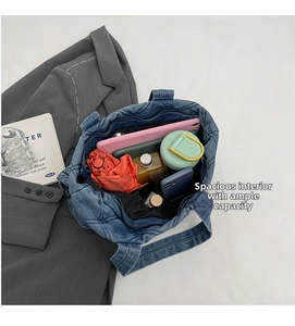 Vue intérieure du grand sac cabas en jean bleu matelassé avec des objets quotidiens