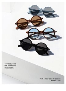 Various colors of vintage round oversized sunglasses displayed on white geometric stands