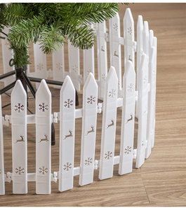 Close-up of white Christmas tree fence with snowflake and reindeer hollow patterns