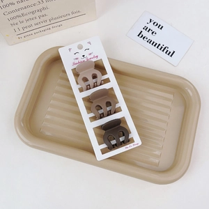 Three-piece set of matte brown gradient mini hair claws on a textured display tray