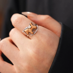 Detailed view of rocking horse ring featuring wood inlay and cubic zirconia on model finger