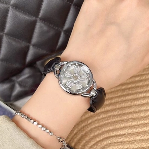 Women's watch with rotating crystal flower dial and black leather strap on wrist