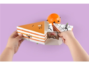 Detail of opening a triangle cake-shaped Halloween gift box with orange stripes and spiders