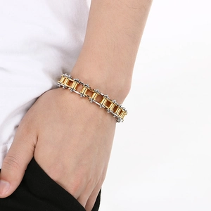 Close-up of a two-tone gold and silver stainless steel bicycle chain bracelet on wrist