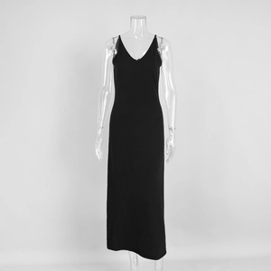 Detail of the deep V-neckline and slim spaghetti straps on a black knit maxi dress