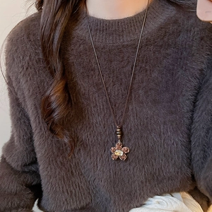 Detail of leopard print flower pendant with rhinestone on vintage sweater chain