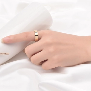 Gros plan d'une bague de 5 mm en acier inoxydable doré avec diamant sur fond de soie blanche