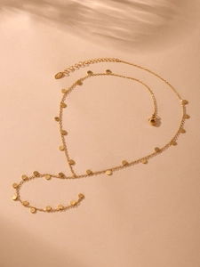 Detail view of gold Y-shaped necklace with round disc pendants and lobster clasp