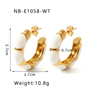 Detailed view of 27mm gold-plated C-shaped enamel hoop earrings with white glaze finish