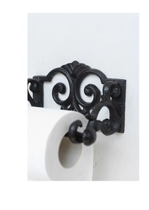 Macro view showing black cast iron towel holder with vintage scroll patterns on white background