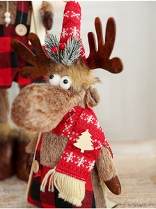 Close-up of plush Christmas reindeer with red snowflake hat and plaid scarf details