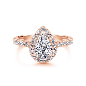 Macro shot of a pear-cut diamond ring with a halo and pave-set rose gold band