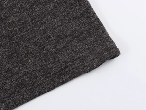 Vue détaillée de la texture du tricot gris foncé et des coutures de l'ourlet inférieur