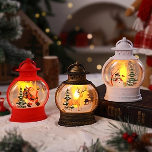 Dettaglio di tre lanterne natalizie festive con luci LED su neve bianca artificiale