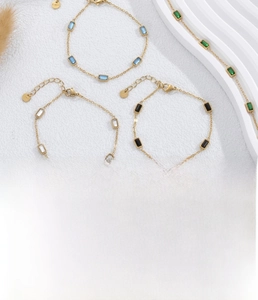 Detail of minimalist gold-plated stainless steel bracelets with colorful cubic zirconia
