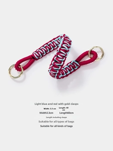 Detail of blue and red woven purse strap with gold ring buckles and size markings