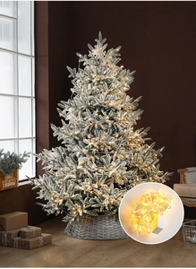 Detailed view of artificial snow-flocked Christmas tree with warm white LED string lights