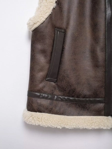 Detail of vintage brown leather vest showing plush faux shearling lining and stitching