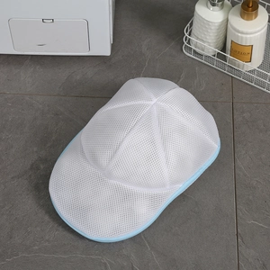 White mesh laundry bag for hats with blue zipper on a grey marble tile background