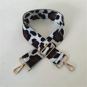 Detail of adjustable leopard print bag strap with golden metal lobster clasps and buckle