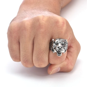 Close-up of a vintage silver tiger head ring in punk style on a model finger