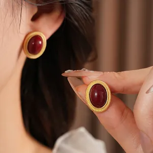Vintage gold oval earrings with burgundy center and twisted rope border