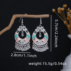 Detail of ethnic silver drop earrings with colorful enamel and jingling bell charms
