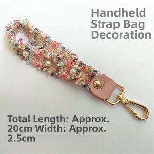 Detail view of colorful tweed wrist strap with pearls and 20cm length dimension