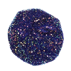 Close-up of dark blue velvet beret hat with colorful sequins on a clean white background