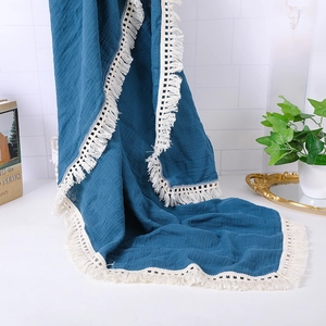 Detail of navy blue muslin baby blanket with white lace fringe and crinkle texture
