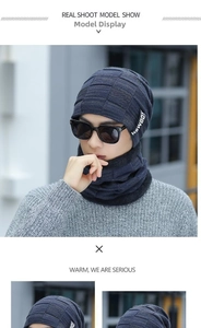 Detail of navy blue knitted beanie and neck warmer set with plaid texture and logo label