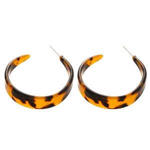 Boucles d'oreilles créoles en résine en forme de C avec motif léopard ambre sur fond blanc