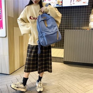 Blue large capacity backpack with fashion zipper detail and nylon texture shown on model