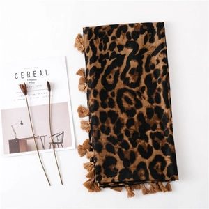Elegant leopard print cotton linen scarf with tassel edges on minimalist background