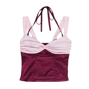 Dettaglio del crop top in raso con pannelli a contrasto rosa e bordeaux e busto arricciato