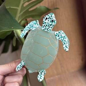 Detailed view of turtle-shaped acetate hair claw clip with golden honeycomb pattern